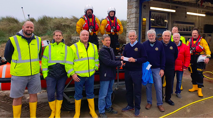 Bude Rotary Club president Rob Cox and several Rotary Club members with Michael Walker and other members of the RNLI team after a recent training session in very challenging conditions in the water off Summerleaze Beach