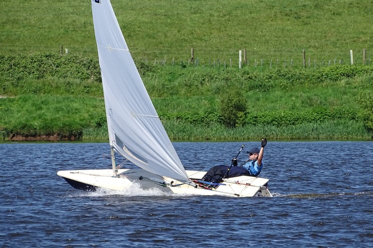 Nathan Pollard raises his hand in thanks to the race officer as he planes over the finish line of the second race.