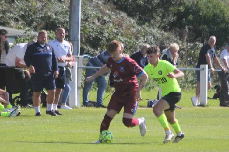 Launceston debutant Lewis Clarke aims to keep the ball under pressure from Liskeard midfielder Will Gilbert. Picture: Paul Hamlyn