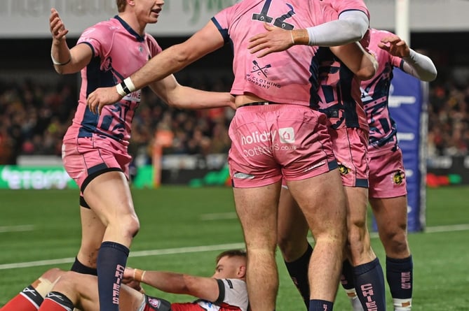 Try-scorer Will Rigg (12) is congratulated on his try by team-mates Josh Hodge and Tom Wyatt