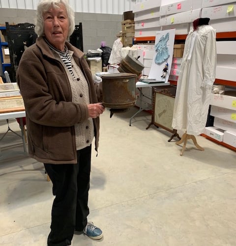 Lawrence House Museum volunteers extended a warm welcome to members of the Coad’s Green WI. Volunteer Carol Bunbury holds the ‘Mystery Object’, against a background of samplers and hand stitched clothes